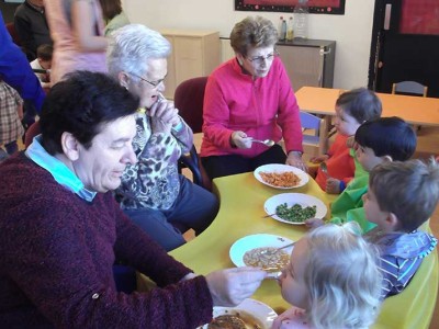 Amonas y aitonas del Centro de Día de Personas Mayores de Arrasate dan de comer a niñas y niños de Arizmendi Personas mayores del Centro de Día Aita Menni de Arrasate dan de comer a niños y niñas de la Ikastola Arizmendi