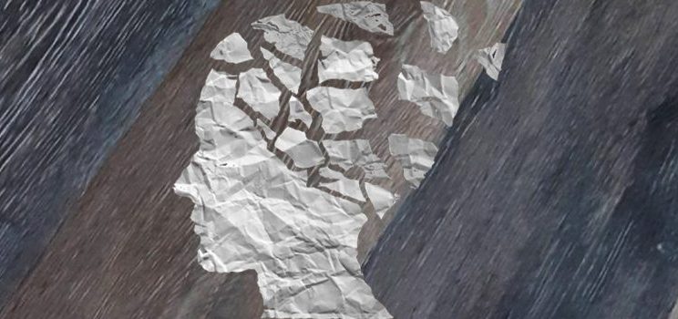 Imagen que representa la amnesia, con una silueta de una cabeza humana recortada en papel con la zona craneal rota en pedazos