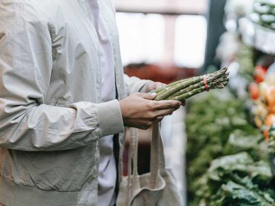 Una persona sosteniendo unos espárragos verdes en un supermercad (Foto: Michael Burrows)