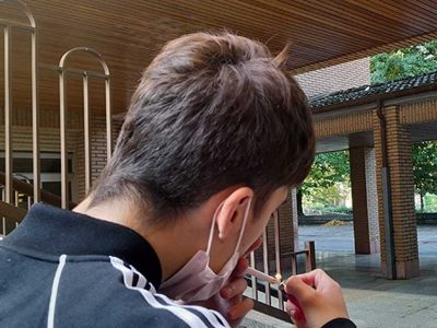 Un joven, encendiendo un cigarrillo