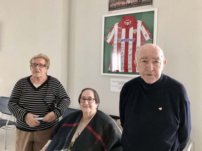 Caridad, Miren y Dionisio posan ante una camiseta firmada por Iribar y otros jugadores del Athletic