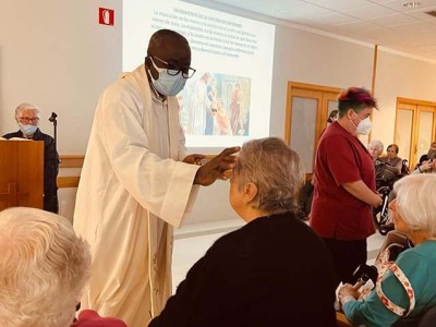 Gaixoaren Pazkoa ospatu dugu Un sacerdote administra el sacaramento de la unicón a una residente de Txurdinagabarri
