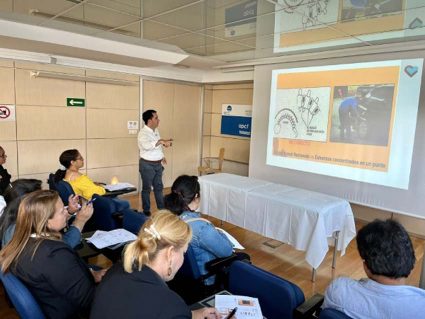 Seminario sobre técnicas de movilización y transferencias para personas con discapacidad neurológica Iban Arrien, ante una pantalla con una diapositiva de su exposición. A su derecha, parte del público asistente a su seminario.