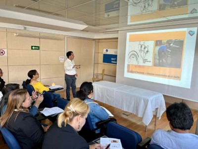 Seminario sobre técnicas de movilización y transferencias para personas con discapacidad neurológica Iban Arrien, ante una pantalla con una diapositiva de su exposición. A su derecha, parte del público asistente a su seminario.