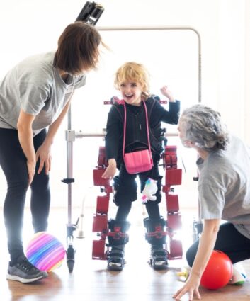 Atlas 2030 exoeskeletoaren erabilera haurren garun paralisia duten haurrengan Irma García eta Nerea Meabe terapeutek 4 urteko Daneleri lagundu diote exoeskeletoarekin ibiltzen