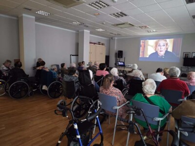 Urriaren 1a, Adinekoen Eguna Un grupo grande de personas mayores sentadas en una sala frente a una pantalla en la que se proyecta la película