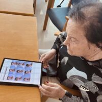 Emozioak lantzen Osasun Mentalaren Munduko Egunean Una mujer mayor observa una tablet con imágenes de distintos rostros con emociones