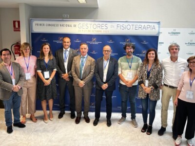 Iban Arrien asiste al I Congreso Nacional de Gestores en Fisioterapia Diez hombres y mujeres, ponentes del Congreso, posan delante del cartel del mismo
