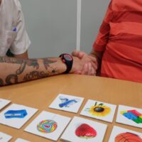 Una terapeuta y un paciente realizan una actividad con fichas de dibujos