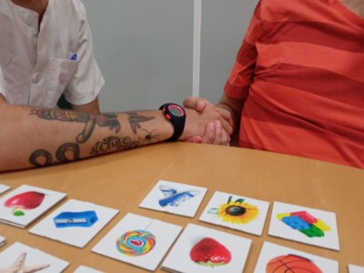 Una terapeuta y un paciente realizan una actividad con fichas de dibujos