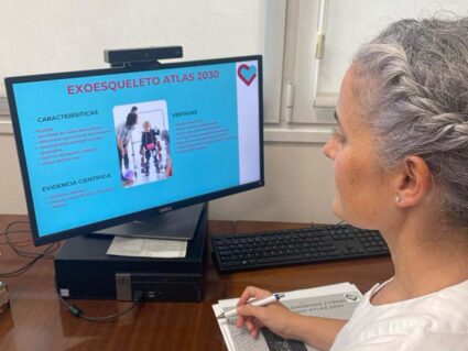 Sesión sobre el exoesqueleto infantil con profesionales de Madrid Irma García Oliveros, ante un ordenador con información sobre el exoesqueleto Atlas 2030