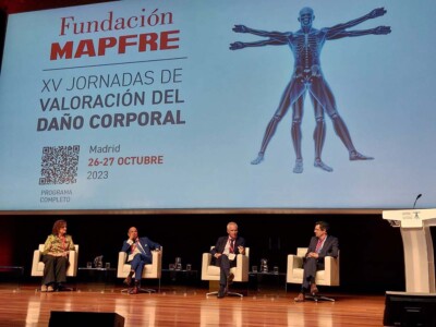Analizamos los cambios en la patología psiquiátrica tras un accidente de tráfico Cuatro personas sentadas en un escenario bajo una pantalla con el título de la jornada