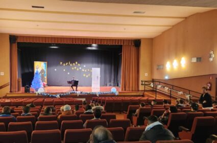 Empieza nuestra programación de Adviento y Navidad Un acordeonista, en el escenario de un salón de actos con público