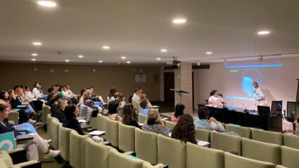 Un grupo de personas en un pequeño auditorio escuchando una intervención