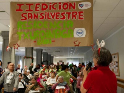 Txurdinagabarriko San Silvestreren II edizioa Un grupo grande de personas mayores espera bajo una pancarta en la que se lee