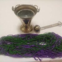 Bendición y quema de los cordones de San Blas Cordones de San Blas verdes y morados, junto a un hisopo