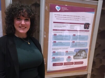 Desgaitasun intelektuala dutenentzako gure asistentzia sarea, Osasun Mentalari eta Errehabilitazio Psikosozialari buruzko IX. Jardunaldietan Minerva de Cos, trabajadora social de Aita Menni, junto al póster elaborado por Macarena Aspiunza, responsable del Área de Discapacidad Intelectual de Hermanas Hospitalarias Aita Menni