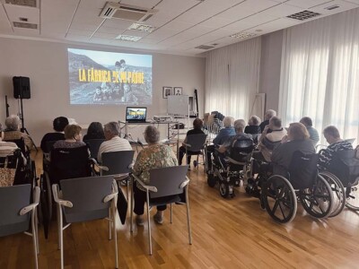 Bizkaiko iragan industriala gogoratuz "La fábrica de mi padre" filmarekin Un grupo de personas mayores sentadas, mirando una pantalla en la que se proyecta un documental