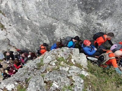 Un grupo de personas trasladan a otra en silla de ruedas por terreno de montaña