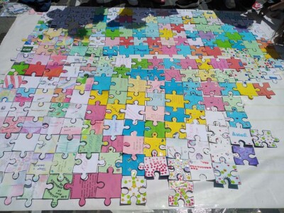 Adineko pertsonenganako begirada aldatzeko puzzle bat Un puzzle hecho con piezas grandes de distintos colores y con inscripciones