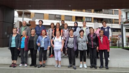 Un grupo de 21 personas, hombres y mujeres, posan en dos líneas en unas escaleras