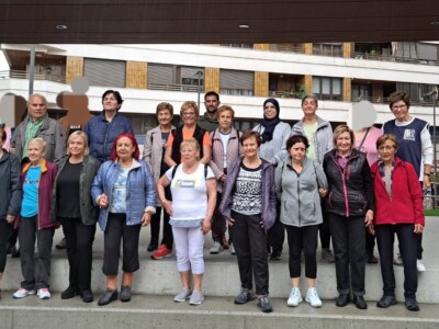 Un grupo de 21 personas, hombres y mujeres, posan en dos líneas en unas escaleras