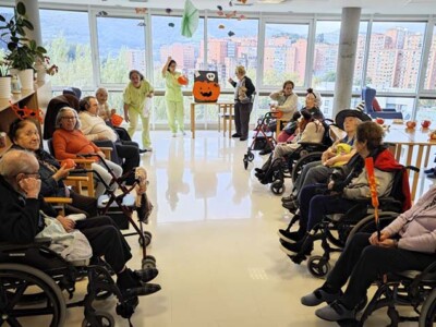 Halloween ospatu dugu jolasekin, sukaldaritzako ekintzekin eta jai tematikoekin Varias personas mayores en una sala decorada con motivos de Halloween