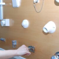 Un panel en el que hay diversos elementos, como una manilla de puerta, un casquillo de bombilla, pestillos, botones...