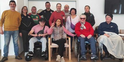 Un grupo de personas, varias en silla de ruedas, posan sonrientes para la fotografía