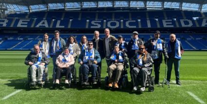 Reale Arenak harrera egin dio berriro gure Erreminiszentzia Tailerrari Un grupo de personas, con bufandas de la Real Sociedad, en el césped del estadio de Anoeta