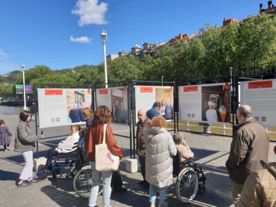 Visitamos la exposición de comercios centenarios de Bilbao Varias personas delante de unos paneles informativos al aire libre