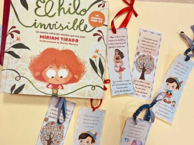 Celebramos el Día del Libro Un libro y varios marcapáginas, sobre una mesa