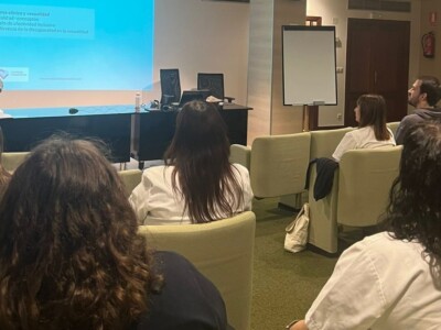 Reflexionamos sobre afectividad y sexualidad en el proceso de rehabilitación Varias personas escuchan a una ponente en un pequeño auditorio