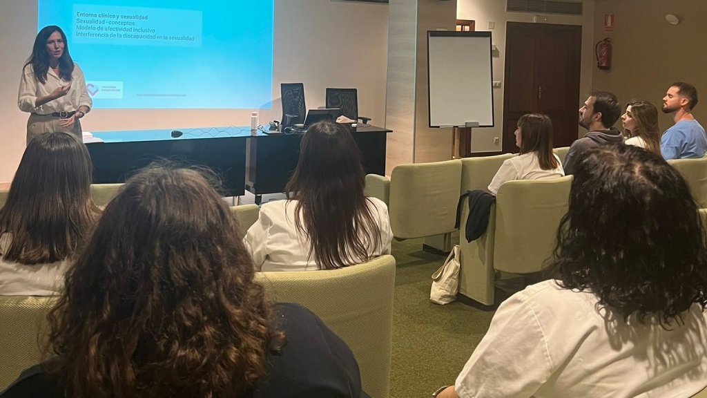 Reflexionamos sobre afectividad y sexualidad en el proceso de rehabilitación Varias personas escuchan a una ponente en un pequeño auditorio