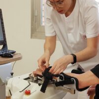 Terapeuta batek paziente baten eskua Amadeo robotean jarriko du goiko gorputz-adarraren errehabilitazio-saio batean