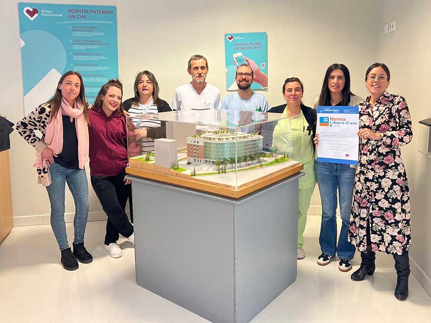 Gure adinekoen egoitza guztiek "Libera inicio" ziurtagiria osatu dute Varias personas, junto a una maqueta de una residencia de personas mayores, mostrando un certificado
