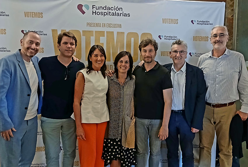 Fundación Hospitalarias presenta en San Sebastián la película "Votemos" Varias personas, delante de un cartel de la película Votemos
