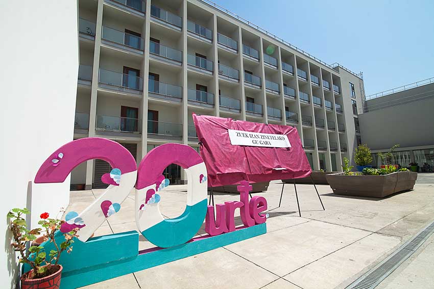 La Residencia Barandiaran de Durango, un hogar que en 20 años ha atendido a 884 personas Un cartel en el que se lee "20 años" en euskera preside el patio del edificio de una residencia de personas mayores