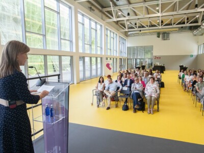 Emakume bat hizketan ari da atril batetik audientzia zabal batera