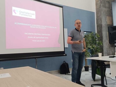 Gizon bat hizketan pantaila baten ondoan