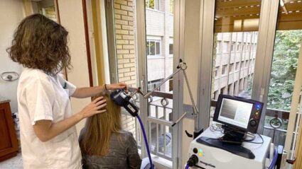 Estimulazio magnetiko transkraniala: garuneko plastikotasunerako leiho bat, errehabilitazioan Terapeuta batek garezurrean zeharreko estimulatzaile bat aplikatzen du paziente baten buruan