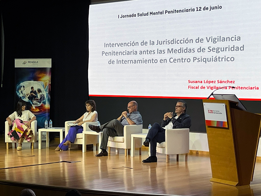 Nuestro psiquiatra Iñaki Madariaga alerta sobre la vulnerabilidad de los presos con enfermedad mental grave Dos mujeres y dos hombres, sentados en un escenario delante de una gran pantalla