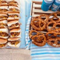 Bratwurstak, pretzelak eta garagardoa goiko terrazan: Prost! Una mesa con salchichas, pretzels y latas de cerveza sin alcohol