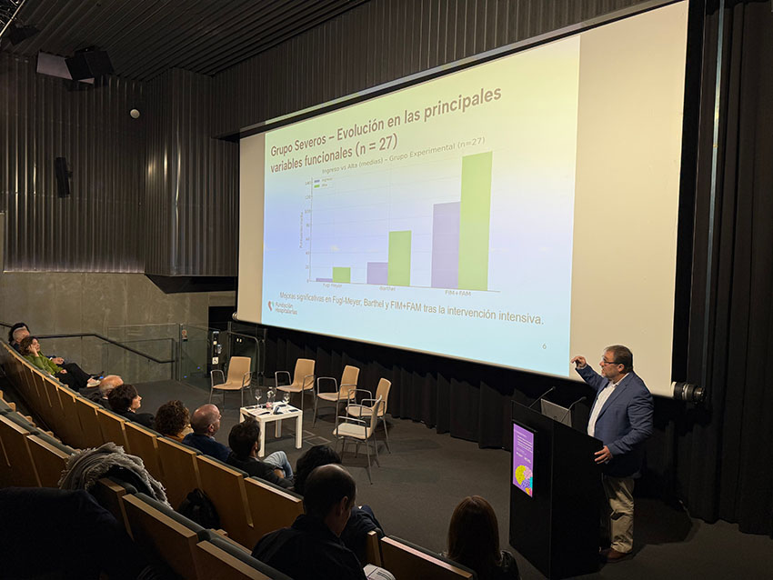 Los últimos avances en atención del ictus, en la jornada de Ospitalarioak Fundazioa Euskadi y ATECE Gipuzkoa Un hombre se dirige a una audiencia. En una pantalla grande se ve un gráfico con datos.