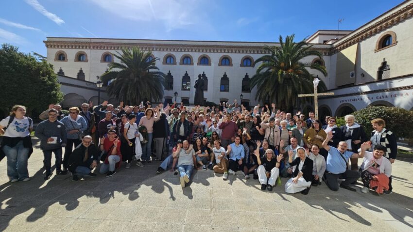 Un amplio grupo de personas posa delante de un edificio