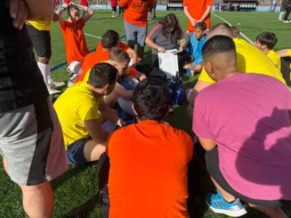 Integrantes de un equipo de fútbol rodean a su entrenadora