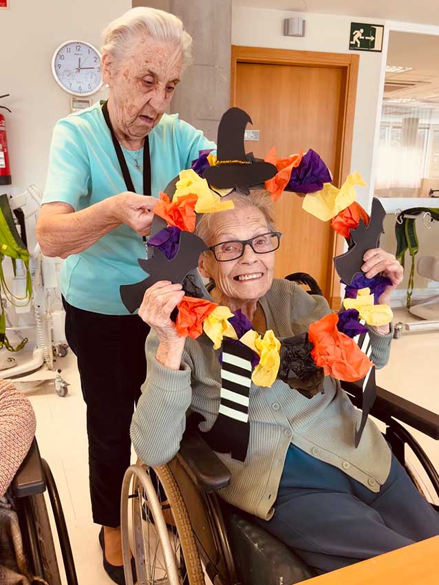 Dos mujeres mayores con un adorno de Halloween