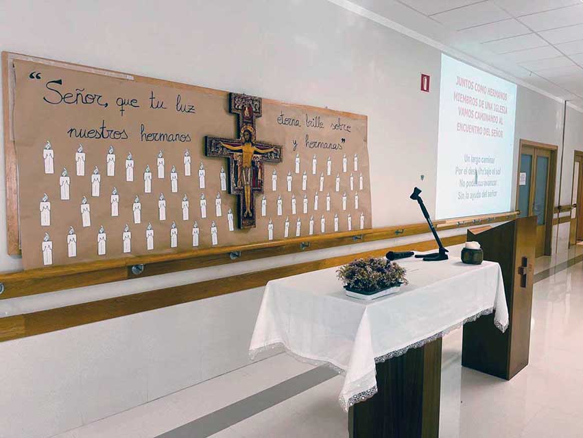 Recordamos a quienes nos han dejado con una emotiva eucaristía Un altar tras el cual hay un crucifijo, y rodeándolo, velas de papel con nombres