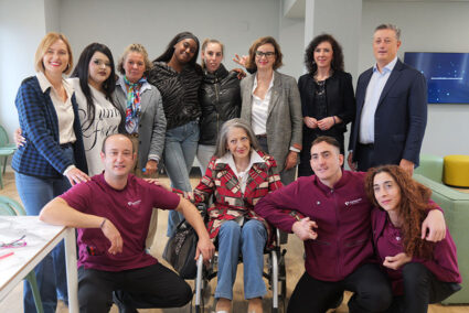 Un amplio grupo de personas posan en una sala