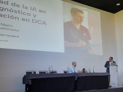 Inteligencia artificial en la valoración y el diagnóstico en daño cerebral: de los modelos predictivos a la práctica clínica diaria Un hombre habla desde un atril en presencia de otro sentado en una mesa